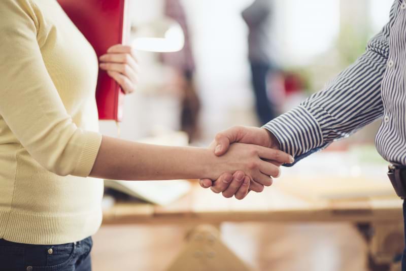 Two people shaking hands after a deal